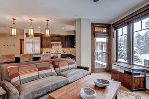 Ein modernes Wohnzimmer mit Sofa, Couchtisch und Essbereich.