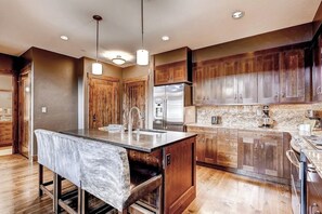 A modern kitchen with wooden cabinets, stainless steel appliances, and a marble countertop. - Bright, luxury condo with pool, hot tubs & gym - walk to lifts & downtown (Breckenridge)