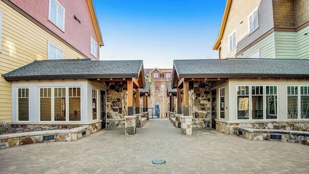A courtyard with stone pillars and a central pathway leading to a building. - Walk-to-lift condo with beautiful view, outdoor pool, hot tubs & fitness center (Breckenridge)