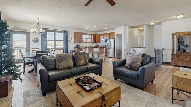 A modern living room with a sofa, coffee table, and a ceiling fan. - Mountain getaway with hot tub, game room, fireplace, and modern interior (Granby)