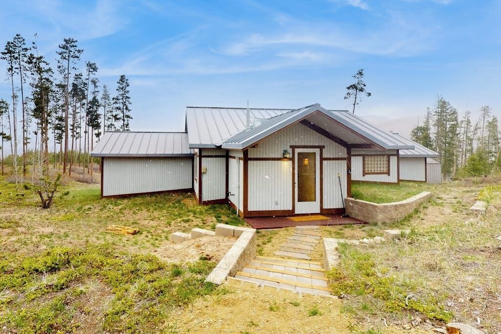 A modern house with a sloped roof, a front door, and a small porch.