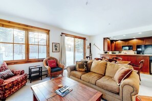 Ein Wohnzimmer mit einer Couch, einem Couchtisch und einem Essbereich mit Stühlen.