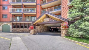 A multi-story hotel with a covered entrance, stone pillars, and a parking area. - Comfy Ski-In Condo w/ Shared Hot Tub & Gas Fireplace - Close to the Mountain (Breckenridge)