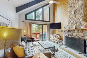 Ein gemütliches Wohnzimmer mit Kamin, Ledersofa und Steinwand.