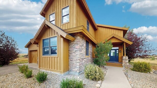 A two-story house with a stone foundation, wooden siding, and a front porch. - Stunning house w/ mountain views, free WiFi, outdoor activities (Granby)
