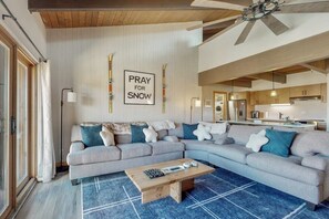 A modern living room with a sectional sofa, a coffee table, and a wall-mounted sign that reads 'PRAY FOR SNOW'. - Ski In on Crested Butte Mountain, Free Shuttle, Great Views, Renovated (Crested Butte)