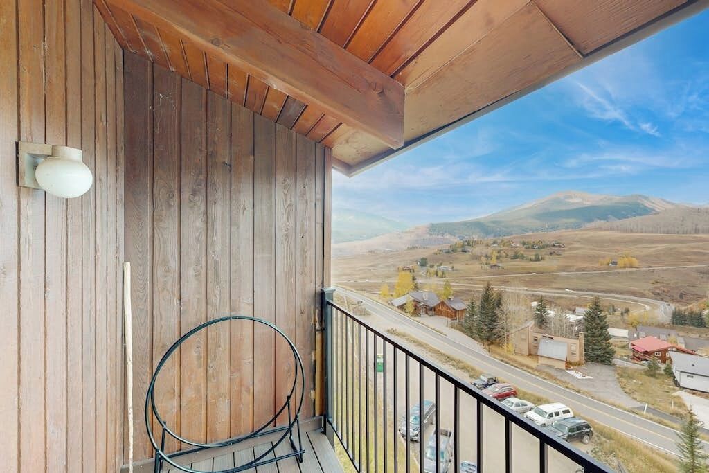 A balcony with a view of a road and distant mountains.