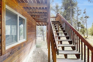 Eine Holzjagdhaushälfte mit einer Treppe zu einer Terrasse.