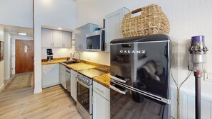 A compact kitchen with a Galanz refrigerator, a microwave, a coffee maker, and a sink.