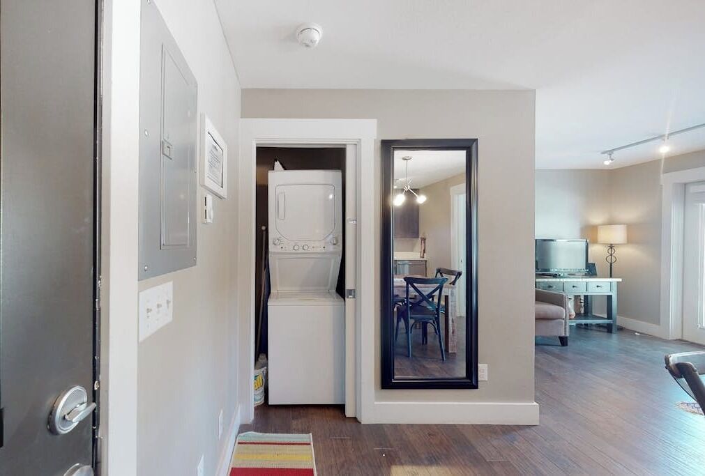 A laundry room with a washing machine, a dryer, and a small table with chairs.