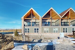 A multi-story building with a stone facade, wooden balconies, and a view of a snowy landscape. - Relax, Recharge, and Explore – Your Perfect Mountain Retreat in Granby, CO (Granby)