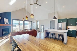 A spacious living area with a wooden dining table, a sofa, and a kitchen with green cabinets and a white island. - Relax, Recharge, and Explore – Your Perfect Mountain Retreat in Granby, CO (Granby)