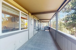 A covered corridor with windows, chairs, and a table. - Quaint getaway steps from Main Street with fireplace & full kitchen (Winter Park)