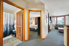 Ein Hotelzimmer mit Bett, Schreibtisch, Sessel, Sofa und Blick ins Freie.