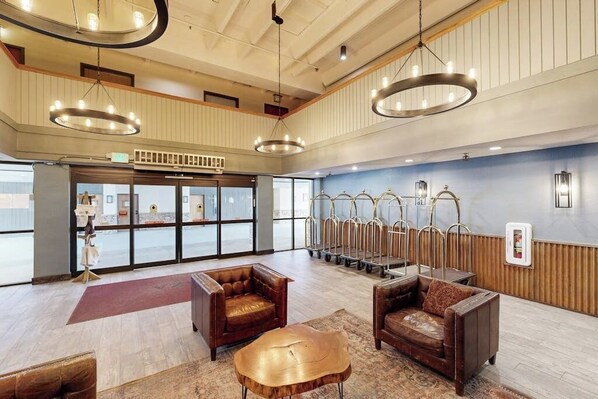 Eine Lobby mit Ledersofas, einem Holztisch und einem großen Fenster mit Blick.
