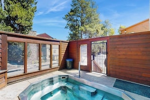 A wooden deck with a hot tub, large windows, and a metal gate. - Cozy condo with easy ski access, W/D, fully stocked kitchen & great location (Breckenridge)