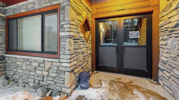 A stone exterior with a wooden door and windows. - Cozy condo with easy ski access, W/D, fully stocked kitchen & great location (Breckenridge)