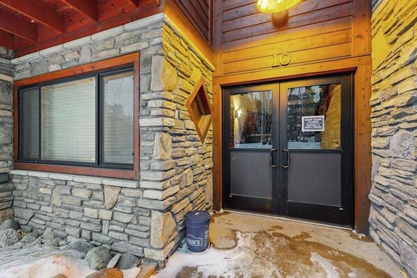 A stone exterior with a wooden door and windows. - Cozy condo with easy ski access, W/D, fully stocked kitchen & great location (Breckenridge)