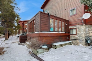 A wooden cabin with a stone foundation, a deck, and a satellite dish. - Cozy condo with easy ski access, W/D, fully stocked kitchen & great location (Breckenridge)
