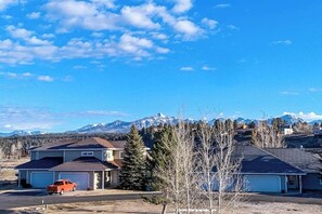 A residential area with houses, a red truck, and a mountain range in the background.