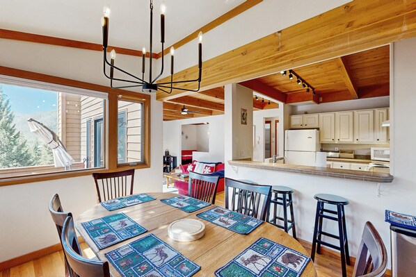 A dining area with a wooden table, chairs, and a chandelier. - Two-story home with exposed beams, a quick walk to the Keystone Lake ice rink (Keystone)