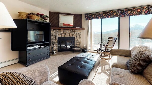 Una sala de estar con chimenea, televisor y sofá.