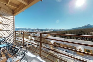 Ein Balkon mit Blick auf eine verschneite Landschaft und Berge.