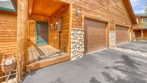 Une cabane en bois avec des fondations en pierre, une porte d’entrée et deux portes de garage.