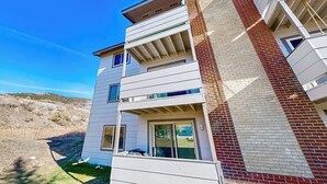 Un edificio residenziale a più piani con un camino in mattoni, balconi e cielo sereno.