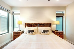 Ein Schlafzimmer mit einem großen Bett, zwei Nachttischen und einem hölzernen Kopfteil.