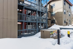 Ein mehrstöckiges Gebäude mit einer Metalltreppe und einem mit Schnee bedeckten Untergrund.