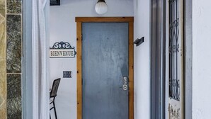 Una puerta con un cartel de 'BIENVENUE', el número '3' en la puerta y un portón metálico a la derecha.