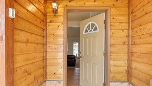 A wooden exterior hallway leading to a door with a white frame and a decorative glass panel. - Hilltop Home w/ Great Mountain Views, Back Porch, WiFi, W/D & Attached Garage (South Fork)