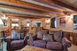 Ein rustikales Holzinterieur mit Ledersofas und einem Essbereich.