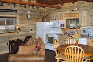 A log cabin interior with a dining area, kitchen, and a cozy living space. - Remodeled, Mountain View Cabin w/ Fireplace, Firepit & WiFi - Dogs Welcome (South Fork)