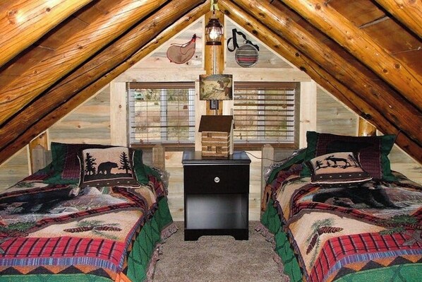 A cozy attic bedroom with two beds, a nightstand, and a wooden ceiling. - Remodeled cabin with fireplace and firepit, 19 miles to Wolf Creek Ski Area (South Fork)