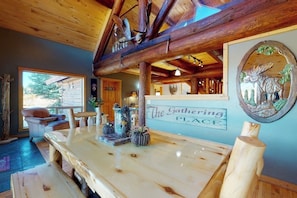 Ein rustikales Interieur mit einem Holztisch, einem Schild mit der Aufschrift 'The Gathering Place' und einem Bild von einem Hirsch.