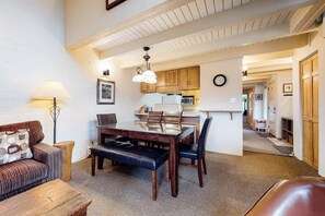 Ein gemütliches Wohnzimmer mit einem Holzesstisch, einer Couch und einer Lampe.