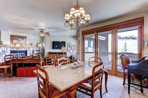 A dining area with a table, chairs, a piano, and a fireplace. - Ski-in/out mountain condo with W/D, free WiFi, pool, & hot tub (Steamboat Springs)