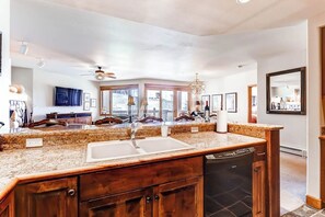 A modern kitchen with granite countertops, a dishwasher, and a large window. - Ski-in/out mountain condo with W/D, free WiFi, pool, & hot tub (Steamboat Springs)