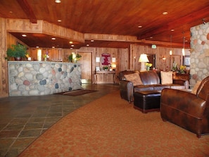 A lobby with a stone wall, leather sofas, a reception desk, and wooden ceiling. - Ski-in/out mountain condo with W/D, free WiFi, pool, & hot tub (Steamboat Springs)