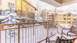 Un balcon offrant une vue sur des bâtiments et des arbres recouverts de neige.