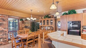 Un intérieur en bois comprenant un coin repas, une cuisine et un mur en briques.