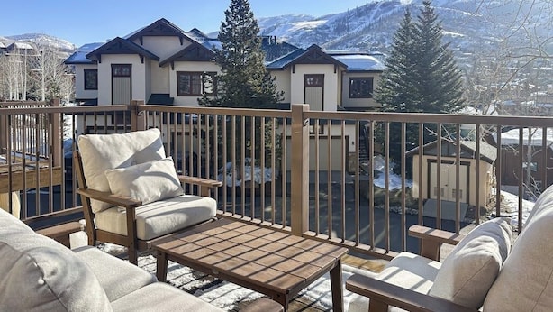 A balcony with outdoor seating, a view of snow-covered mountains, and a clear sky. - Walk-to-lift townhome w/ fireplace, laundry & resort pool/hot tubs/gym/firepit (Steamboat Springs)