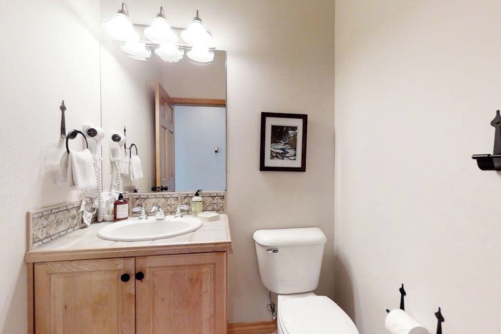 A bathroom with a sink, mirror, and toilet.