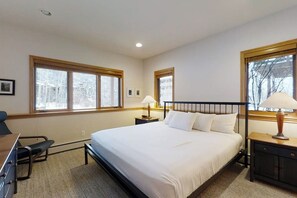 A bedroom with a bed, two bedside tables, a desk, and a chair. - Luxurious Townhome Featuring a Shared Pool and Shuttle (Steamboat Springs)