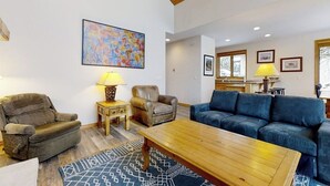 A living room with a sofa, two armchairs, a coffee table, and a rug. - Evergreen 03 Luxurious Townhome Featuring a Shared Pool and Shuttle (Steamboat Springs)