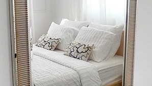 A bedroom with a bed, pillows, and a mirror. - Charming 3-bedroom, 2-bathroom house with AC in quiet neighborhood in Curaçao (Willemstad)