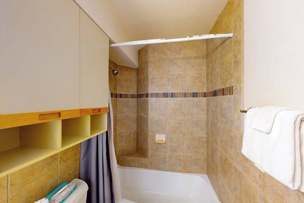 A bathroom with a shower, a toilet, and a sink.