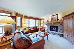 Ein gemütliches Wohnzimmer mit Kamin, Ledersofas und einem Kaminumrandung aus Stein.